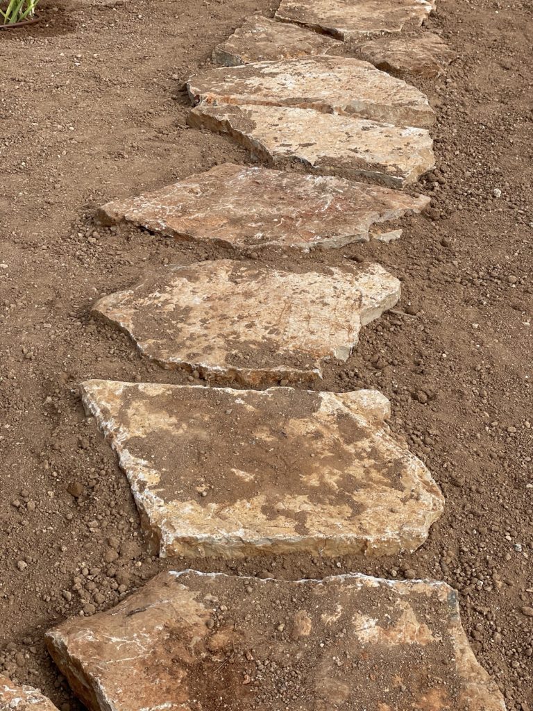 Natural stone slabs laid straight into compacted ground without a concrete base, garden in Mallorca